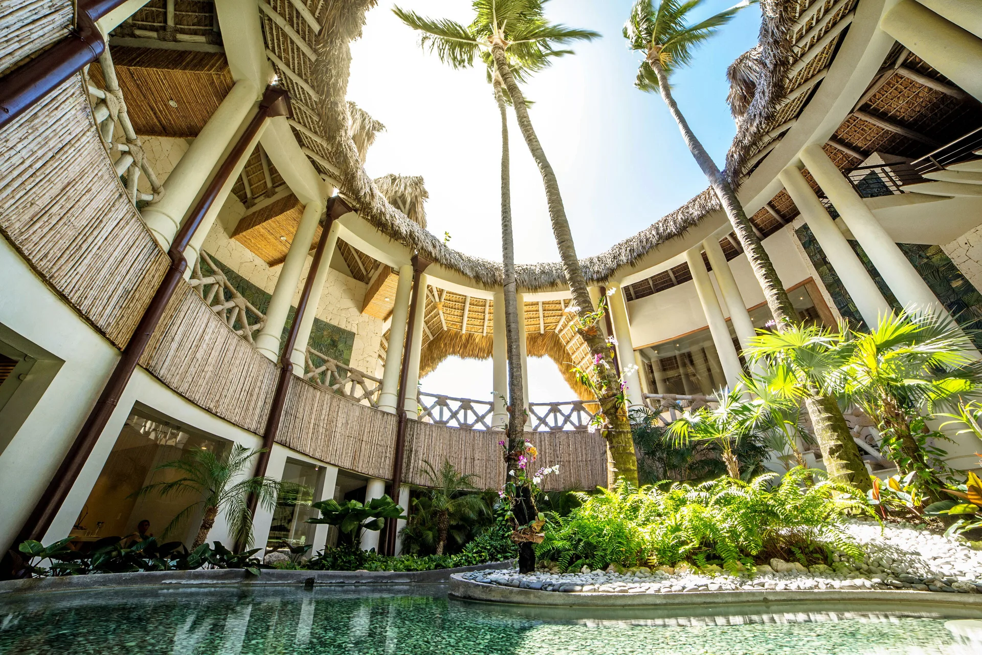 Open-air courtyard with palms and a reflecting pool at Eden Roc Cap Cana.