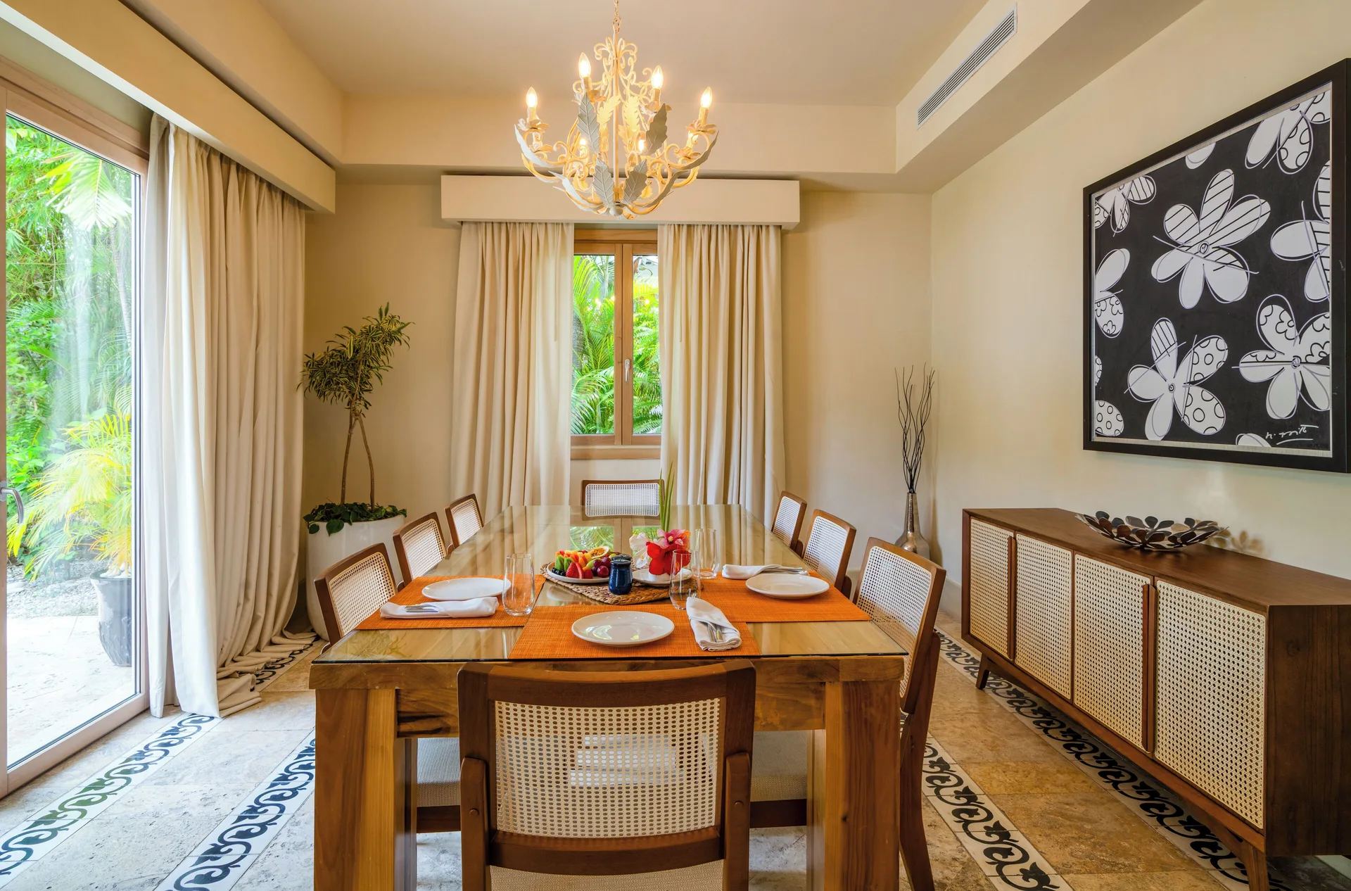 Dining area with a set table, chandelier, and tropical windows at Eden Roc Cap Cana.