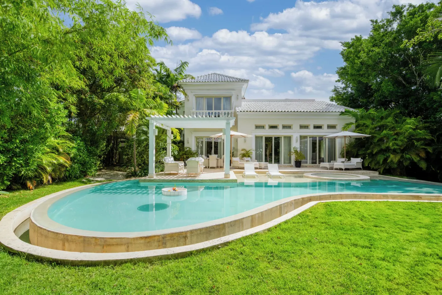 White villa with a curved private pool and garden at Eden Roc Cap Cana.