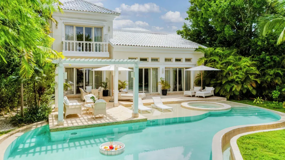 Private villa pool with lounge chairs, umbrellas, and tropical greenery at Eden Roc Cap Cana.