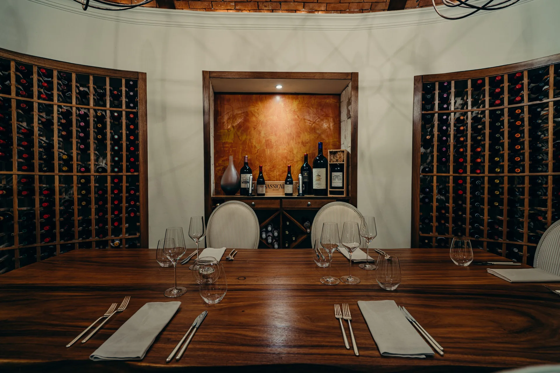 Private wine room at Eden Roc Cap Cana with a long set table and wall racks of bottles.