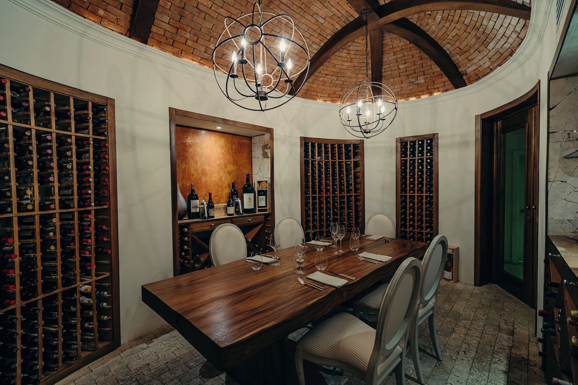 Wine cellar dining room with a long table and bottle racks at Eden Roc Cap Cana.
