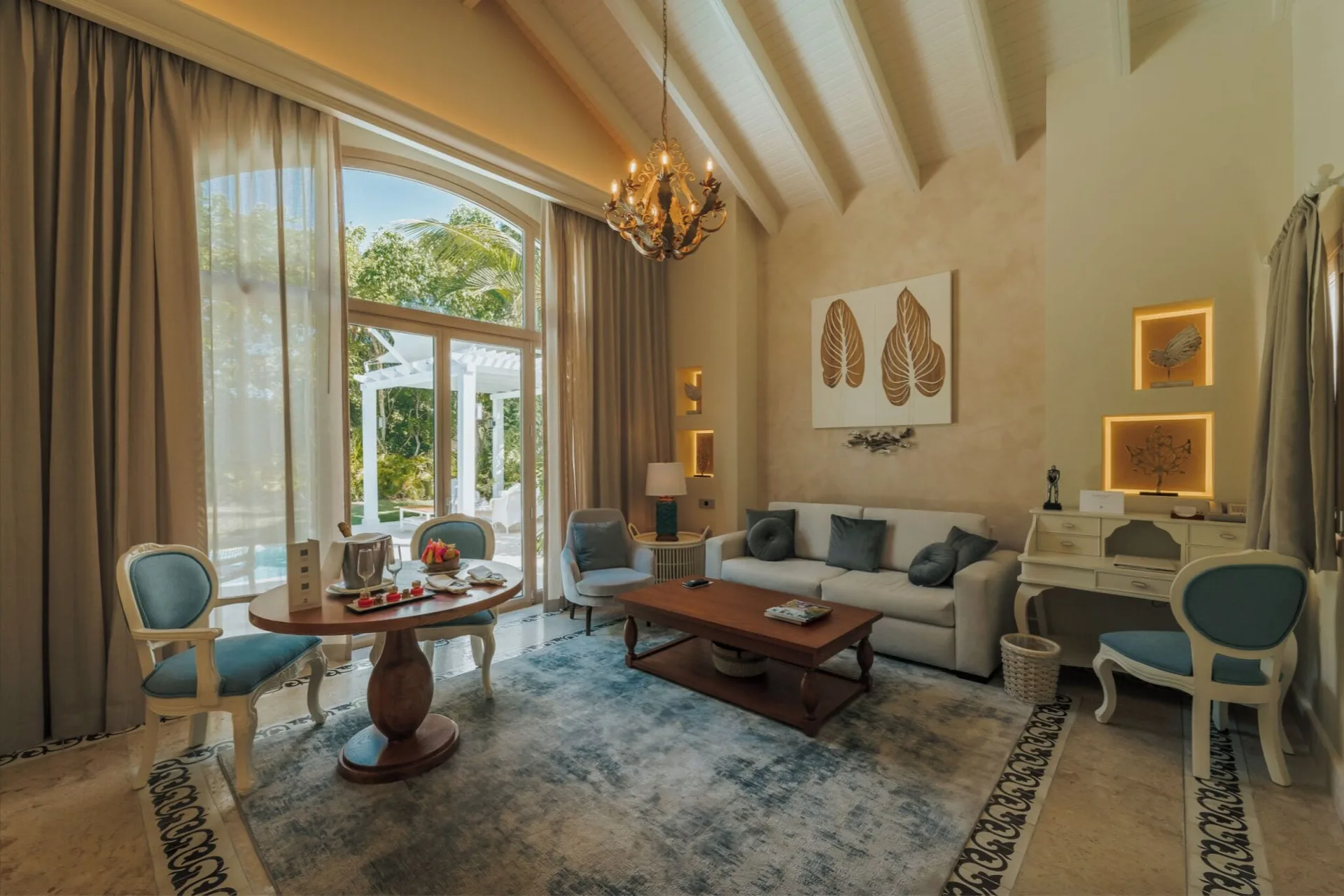 Luxury Pool One Bedroom Suite living room with sofa and tall windows at Eden Roc Cap Cana.