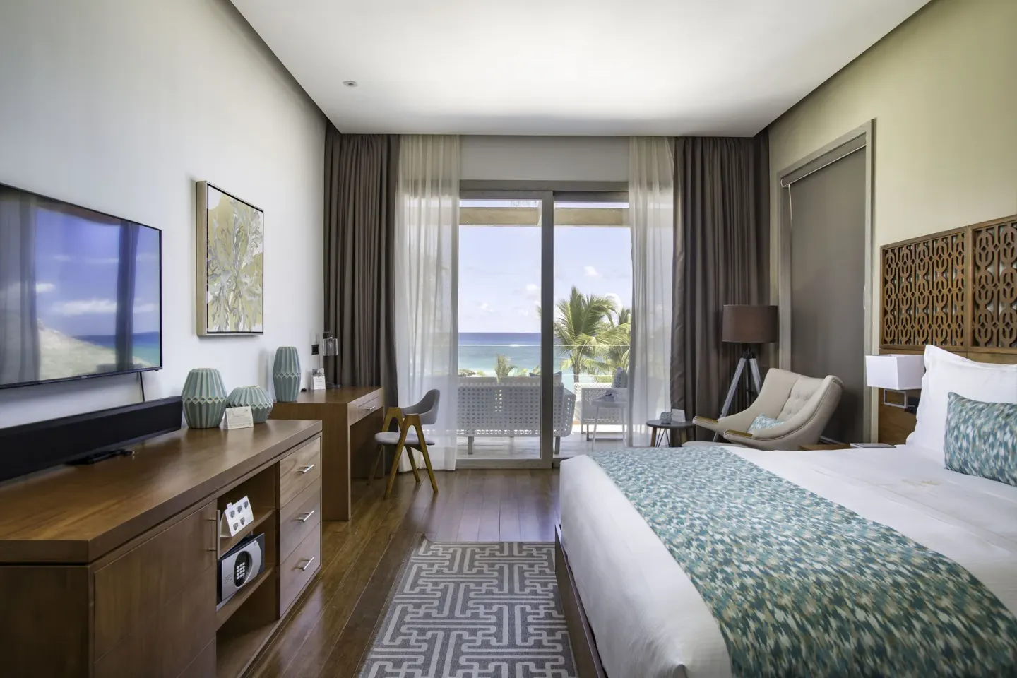 Beachfront one-bedroom suite king bedroom with balcony view at Eden Roc Cap Cana.
