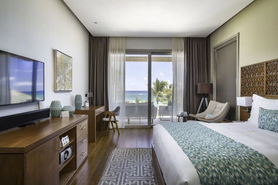 Beachfront one-bedroom suite king bedroom with balcony view at Eden Roc Cap Cana.