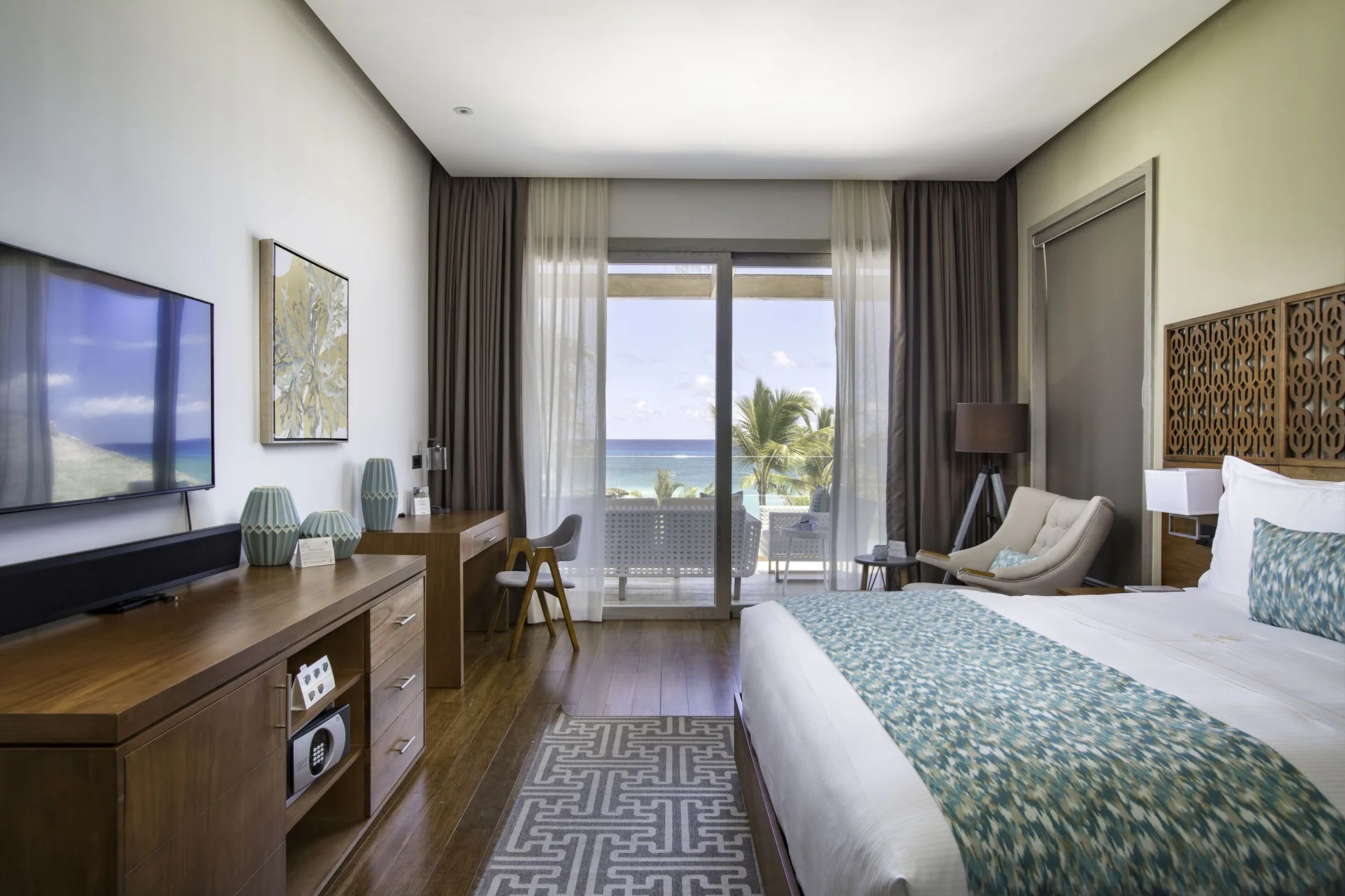 Beachfront one-bedroom suite king bedroom with balcony view at Eden Roc Cap Cana.