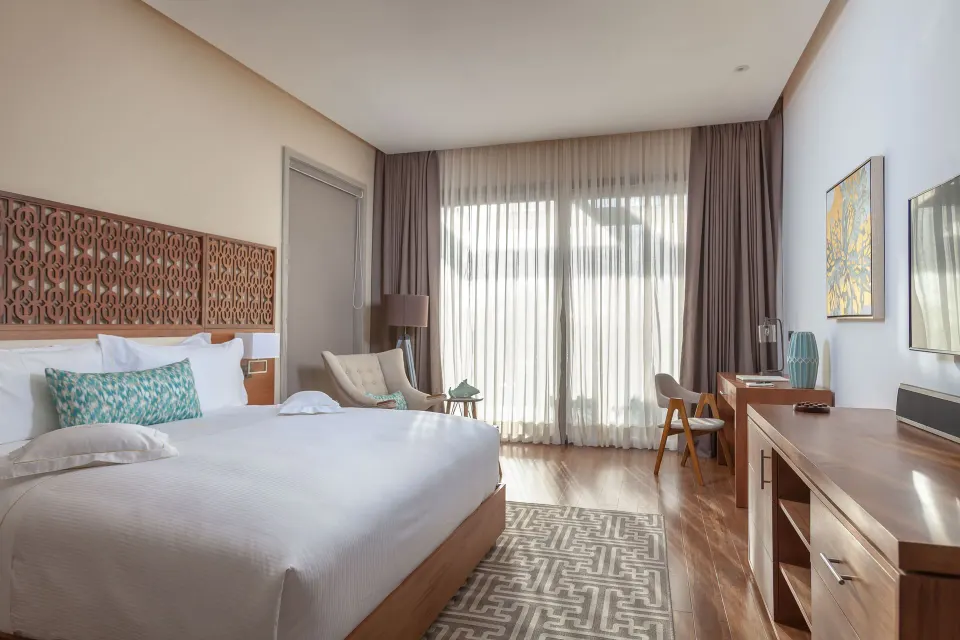 Beachfront one-bedroom suite bedroom with a king bed at Eden Roc Cap Cana.