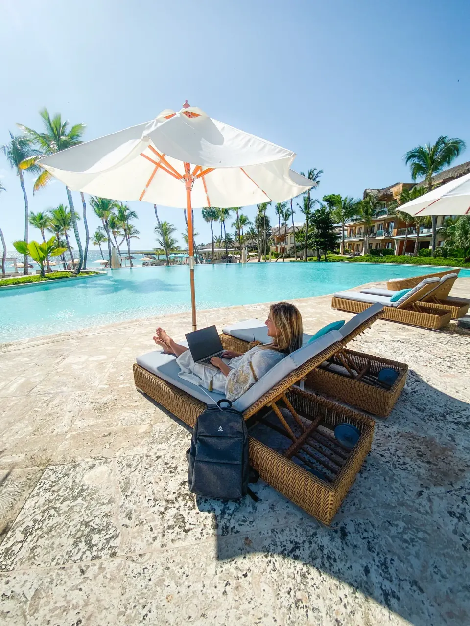 Poolside lounge chairs and umbrella near beachfront suites at Eden Roc Cap Cana.