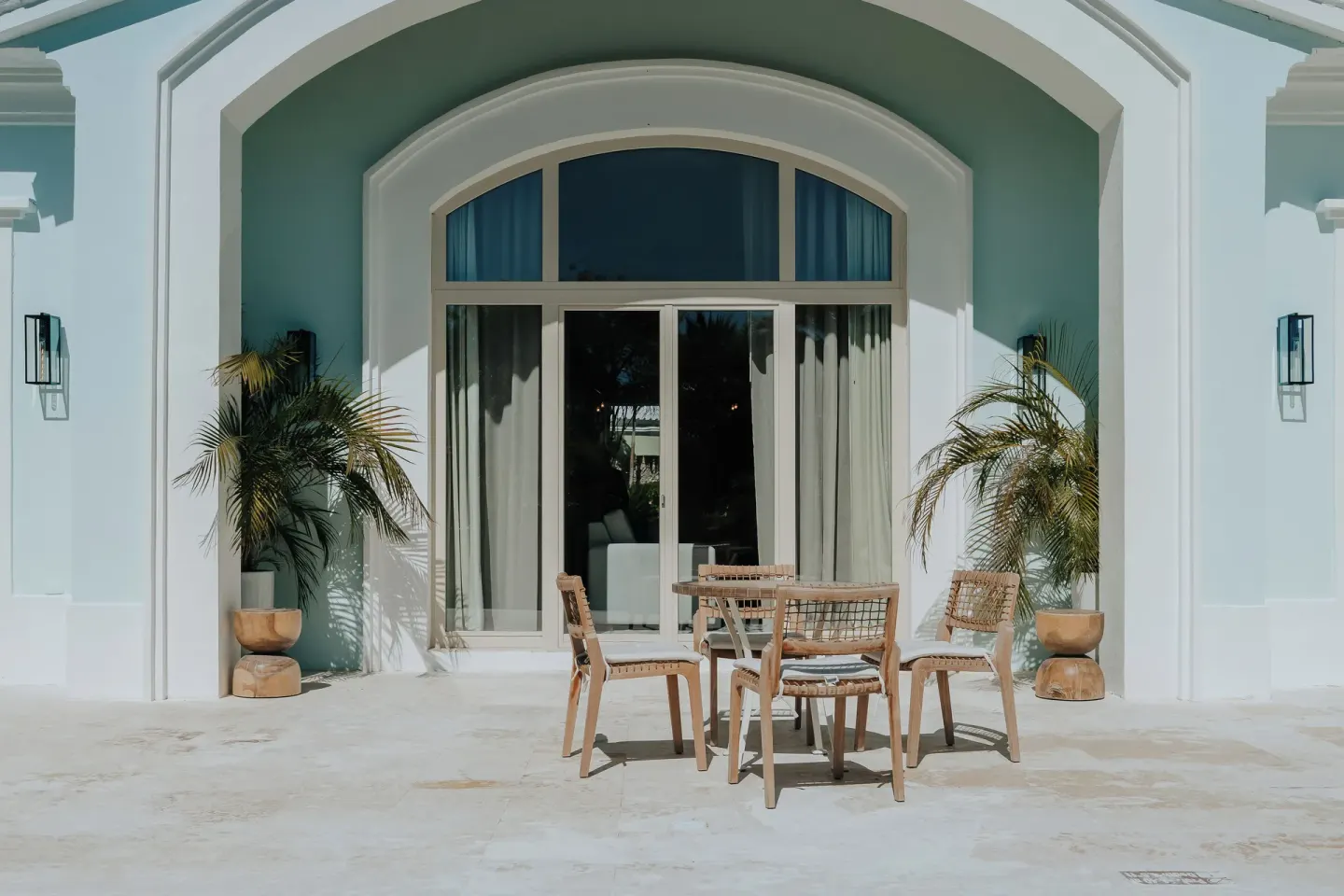 Private terrace of a two-bedroom villa at Eden Roc Cap Cana with outdoor table and potted palms.