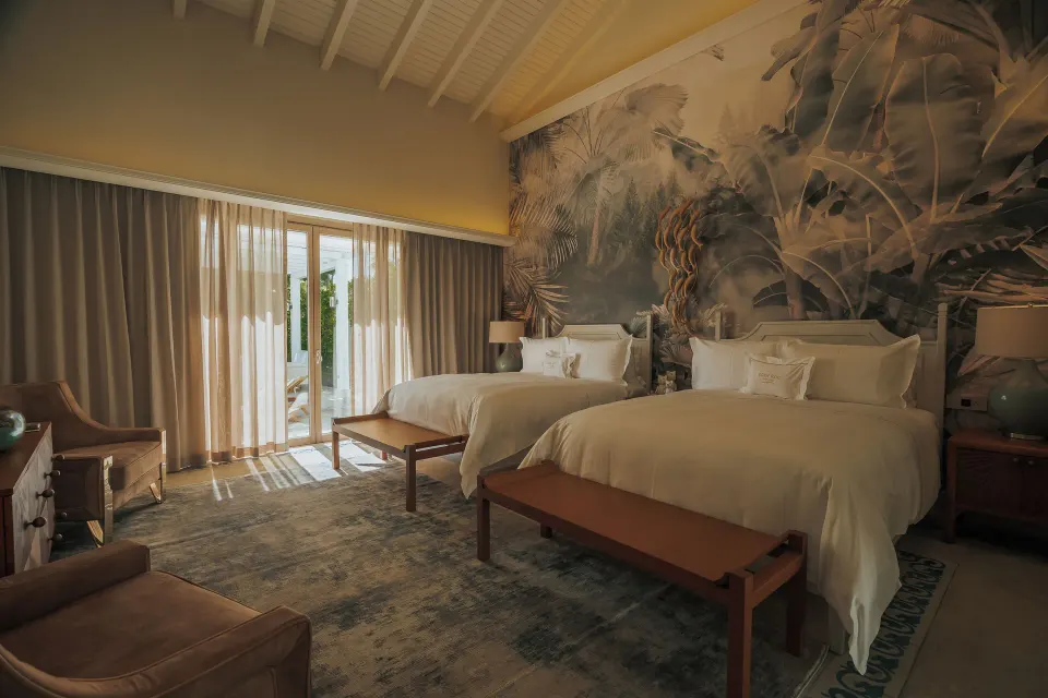 Twin bedroom in a two-bedroom villa at Eden Roc Cap Cana with high ceiling and terrace doors.