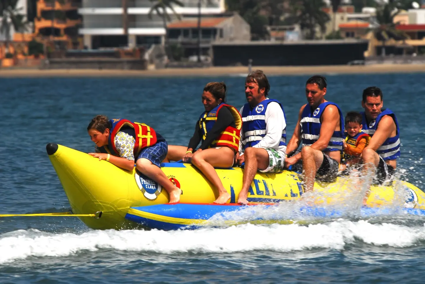 Guests ride a banana boat on the water near El Cid Castilla Beach Hotel.
