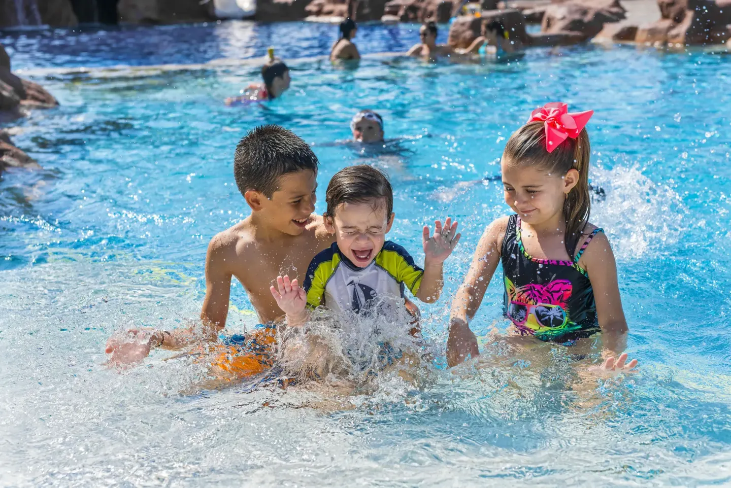 Children splashing in the resort pool at El Cid Castilla Beach Hotel.