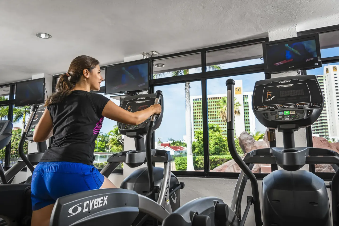 A guest uses an elliptical machine in the fitness center at El Cid Castilla Beach Hotel.