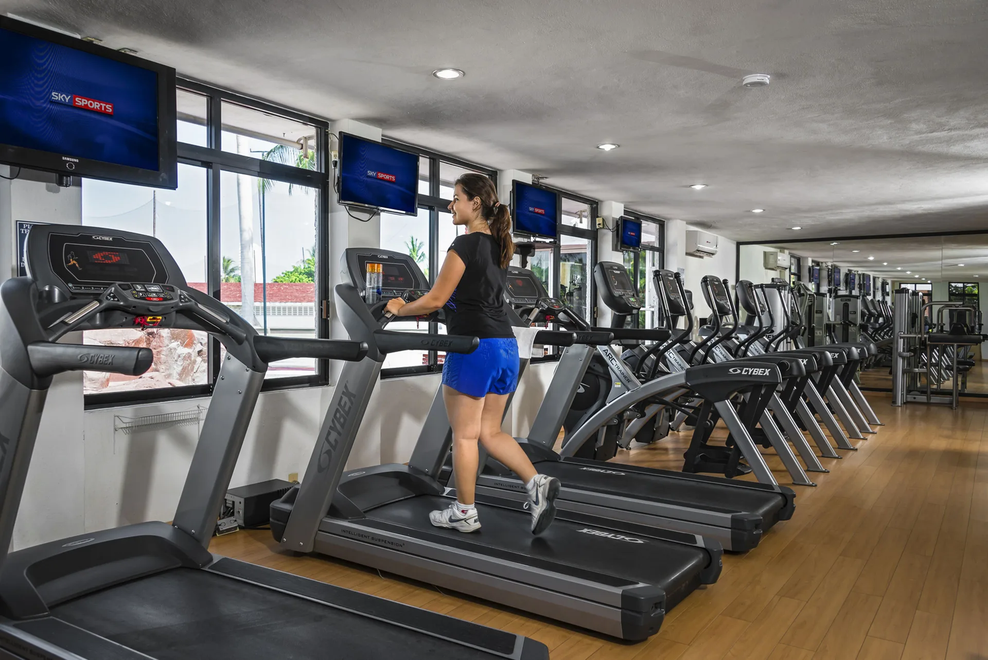 A guest walks on a treadmill in the fitness center at El Cid Castilla Beach Hotel.