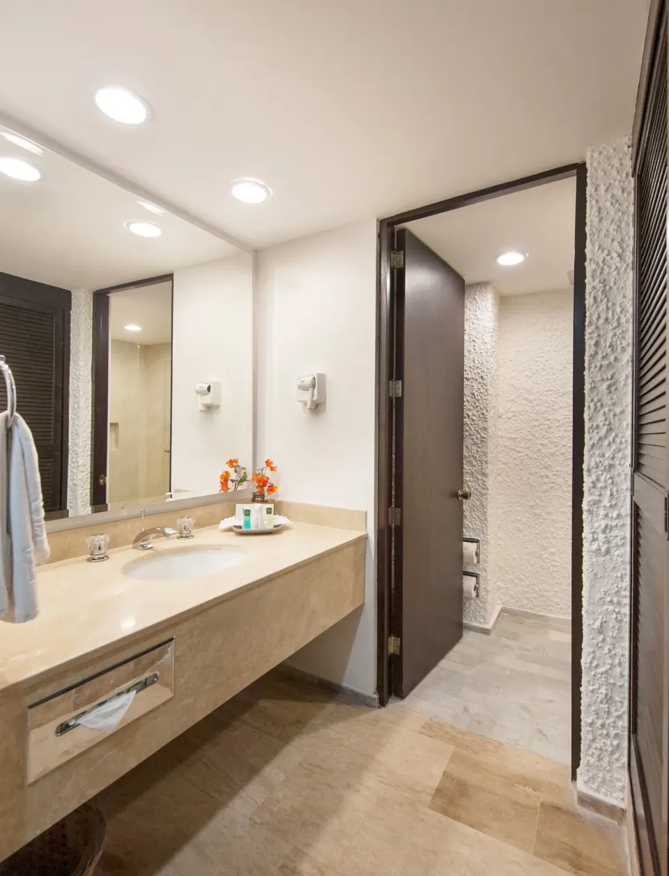 Guest bathroom vanity with mirror and open doorway at El Cid Castilla Beach Hotel.