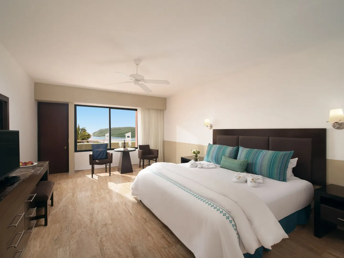 King bed guest room with bright coastal view at El Cid Castilla Beach Hotel.