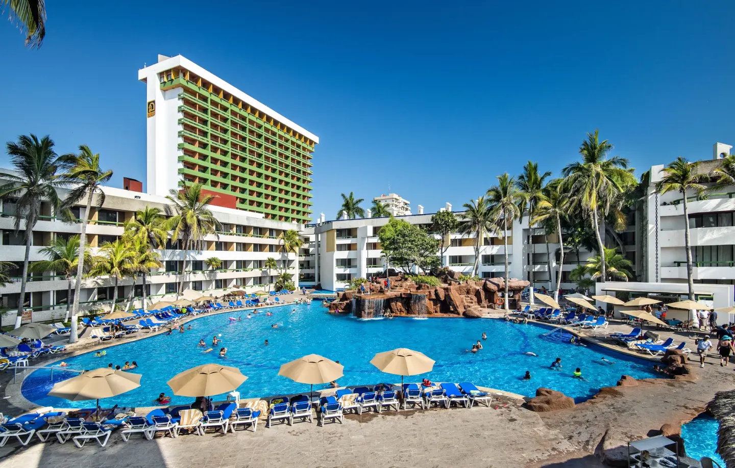 Wide view of the pool courtyard and tower at El Cid Castilla Beach Hotel.