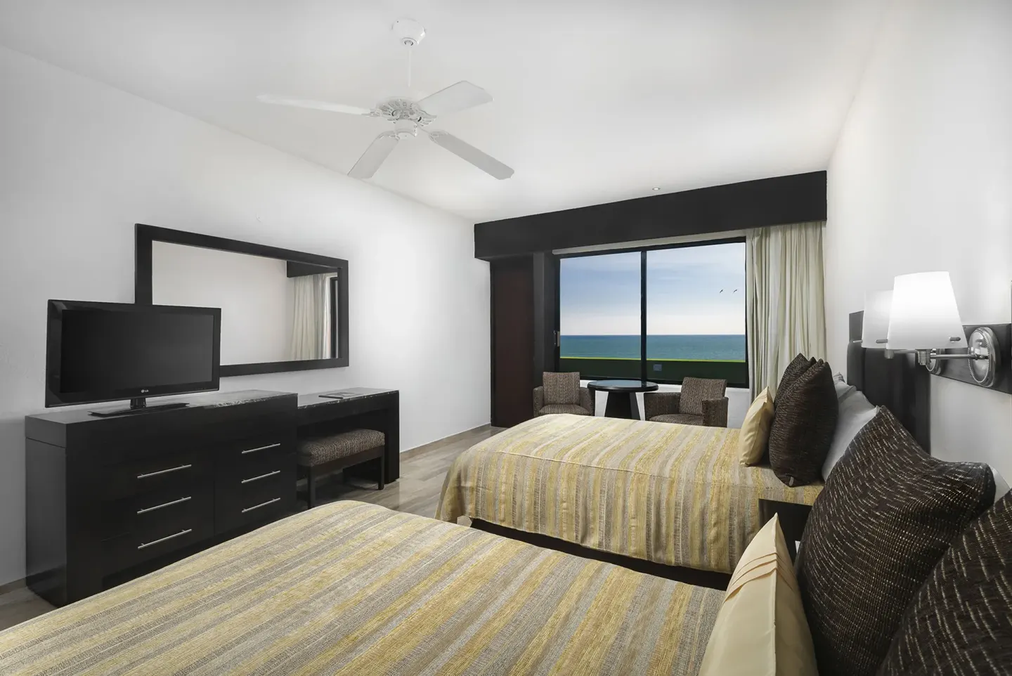 Two-bed guest room with ocean view at El Cid Castilla Beach Hotel.