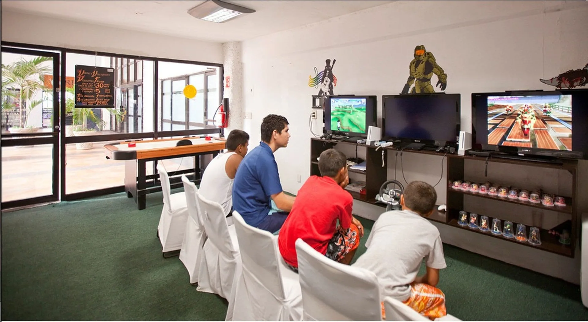 Guests play video games in an activity room at El Cid Castilla Beach Hotel.