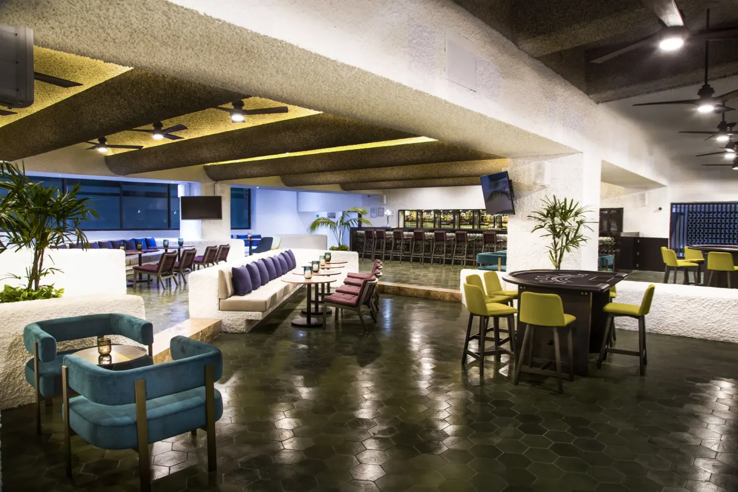 Modern lobby bar seating area with high-top tables at El Cid Castilla Beach Hotel.