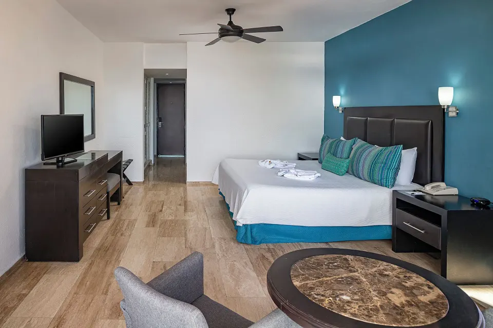 Standard Ocean View king room with teal accent wall at El Cid Castilla Beach Hotel.