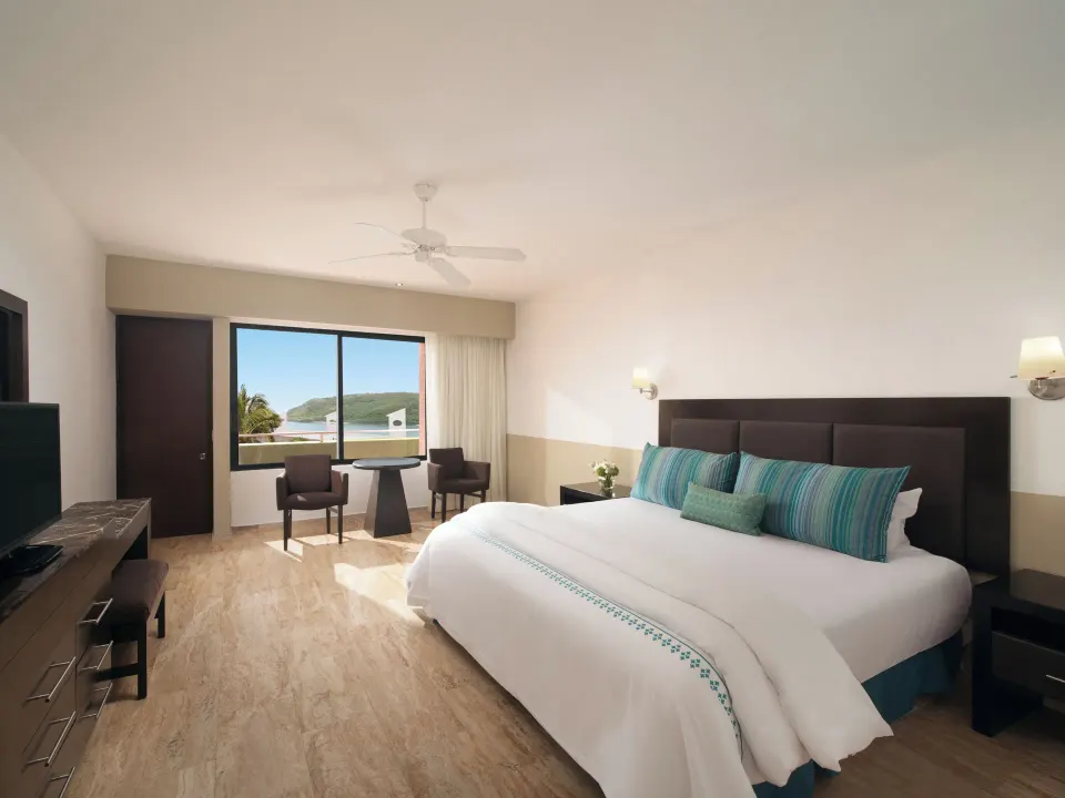 Standard Ocean View room with king bed and sitting area at El Cid Castilla Beach Hotel.