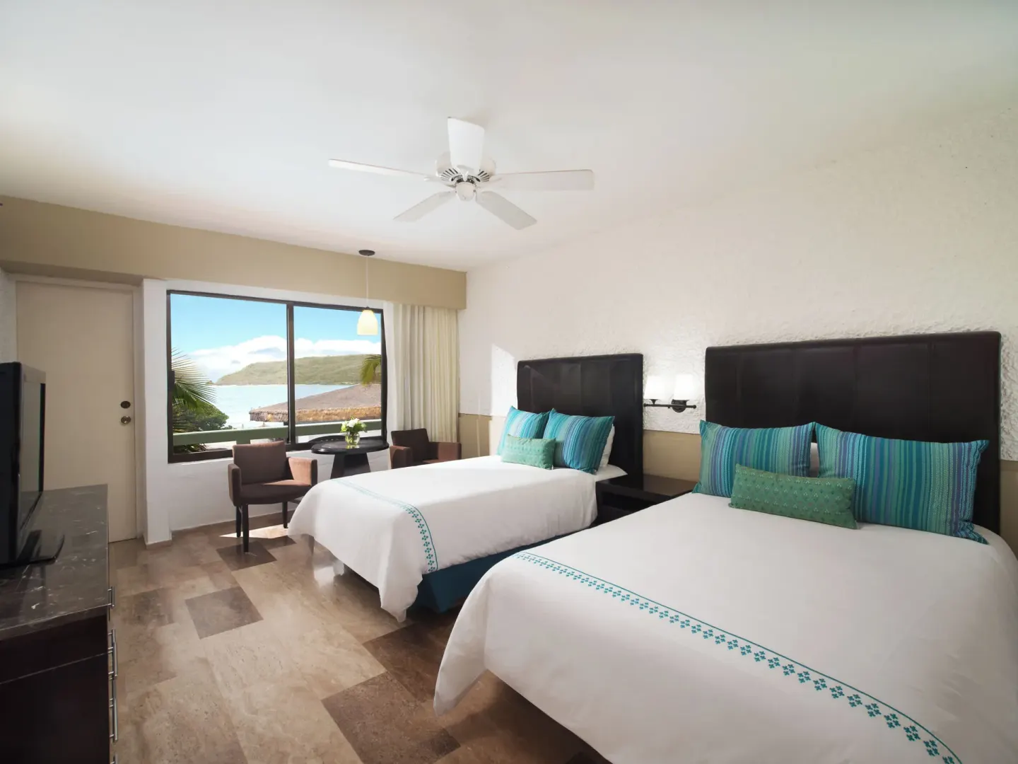 Standard Ocean View room with two beds and large window at El Cid Castilla Beach Hotel.