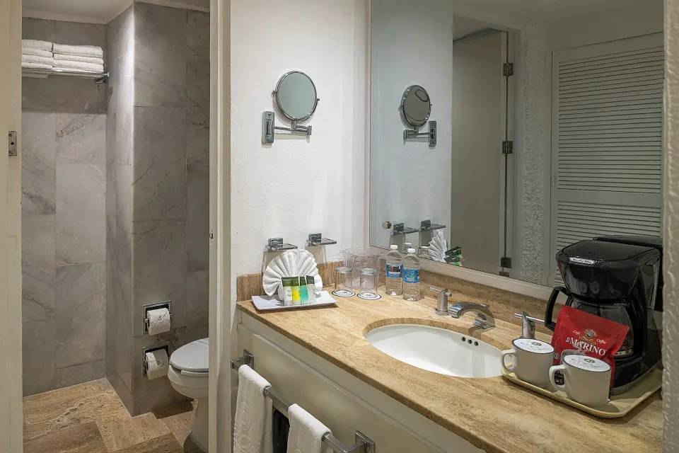 Standard Pool View bathroom vanity and shower area at El Cid Castilla Beach Hotel.