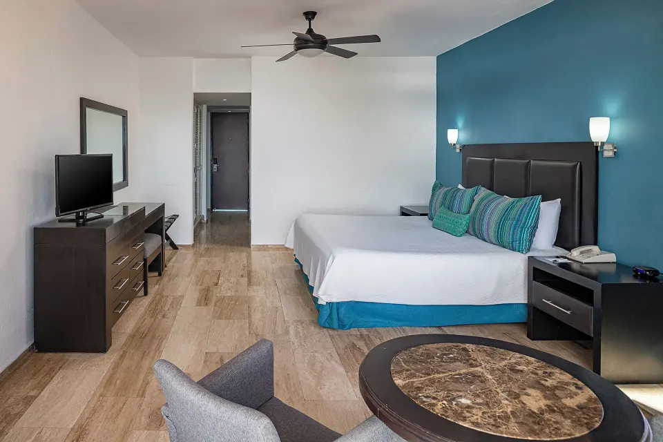 Standard Pool View room with a king bed and blue accent wall at El Cid Castilla Beach Hotel.