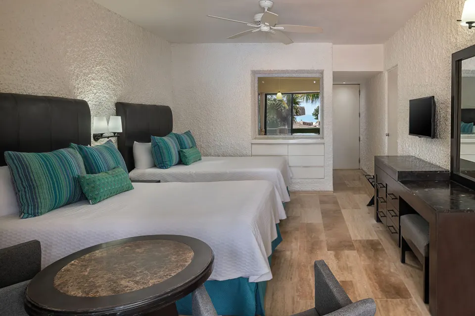 Standard Pool View room with two beds and dresser at El Cid Castilla Beach Hotel.