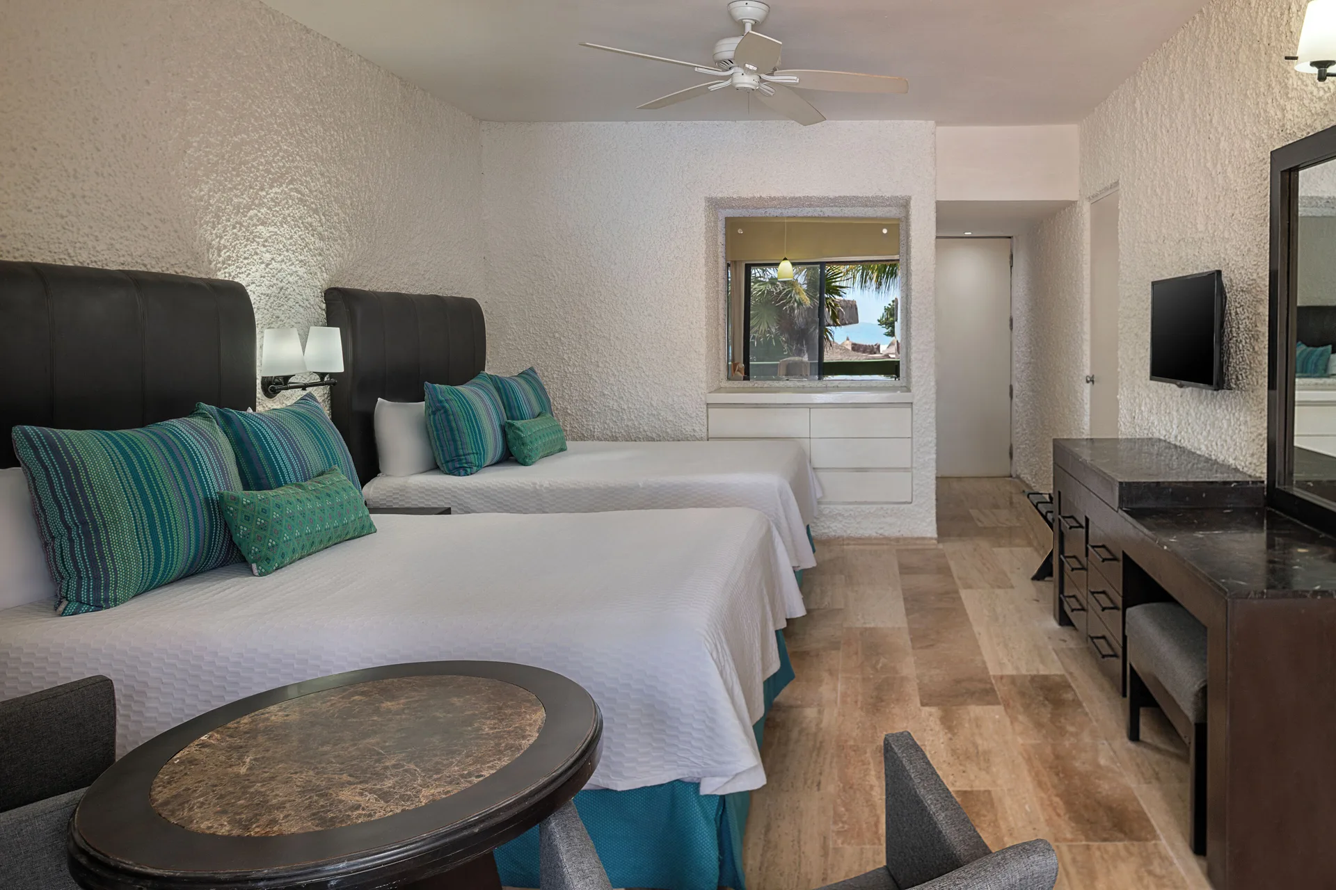 Standard Pool View room with two beds and dresser at El Cid Castilla Beach Hotel.
