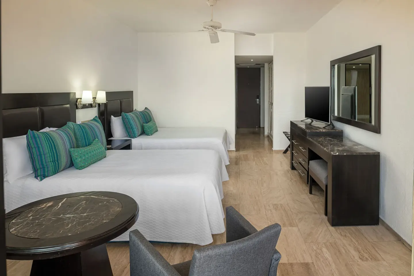 Standard Pool View room with two beds and seating table at El Cid Castilla Beach Hotel.