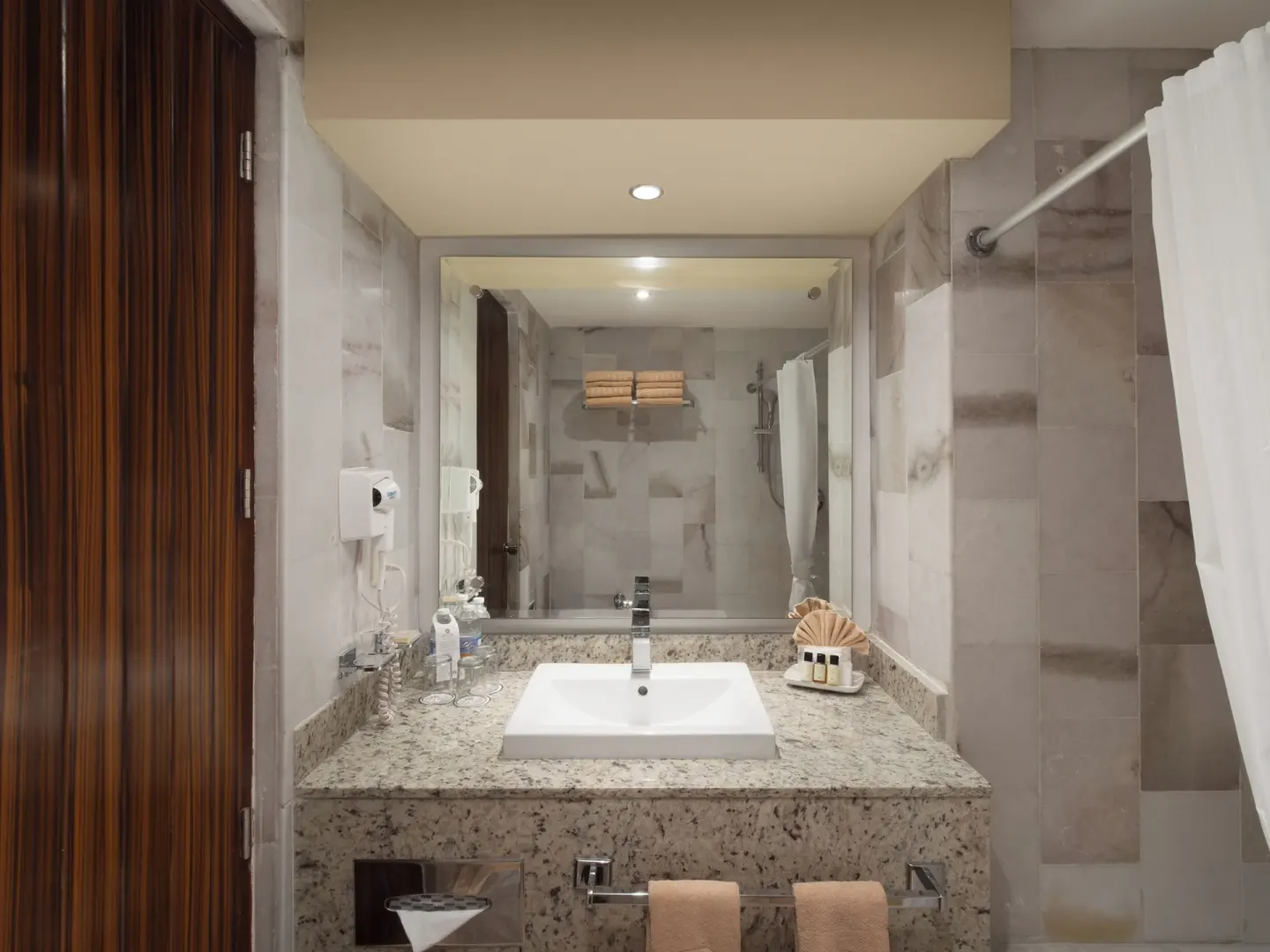 Guest bathroom vanity and shower area at El Cid El Moro Beach Hotel.