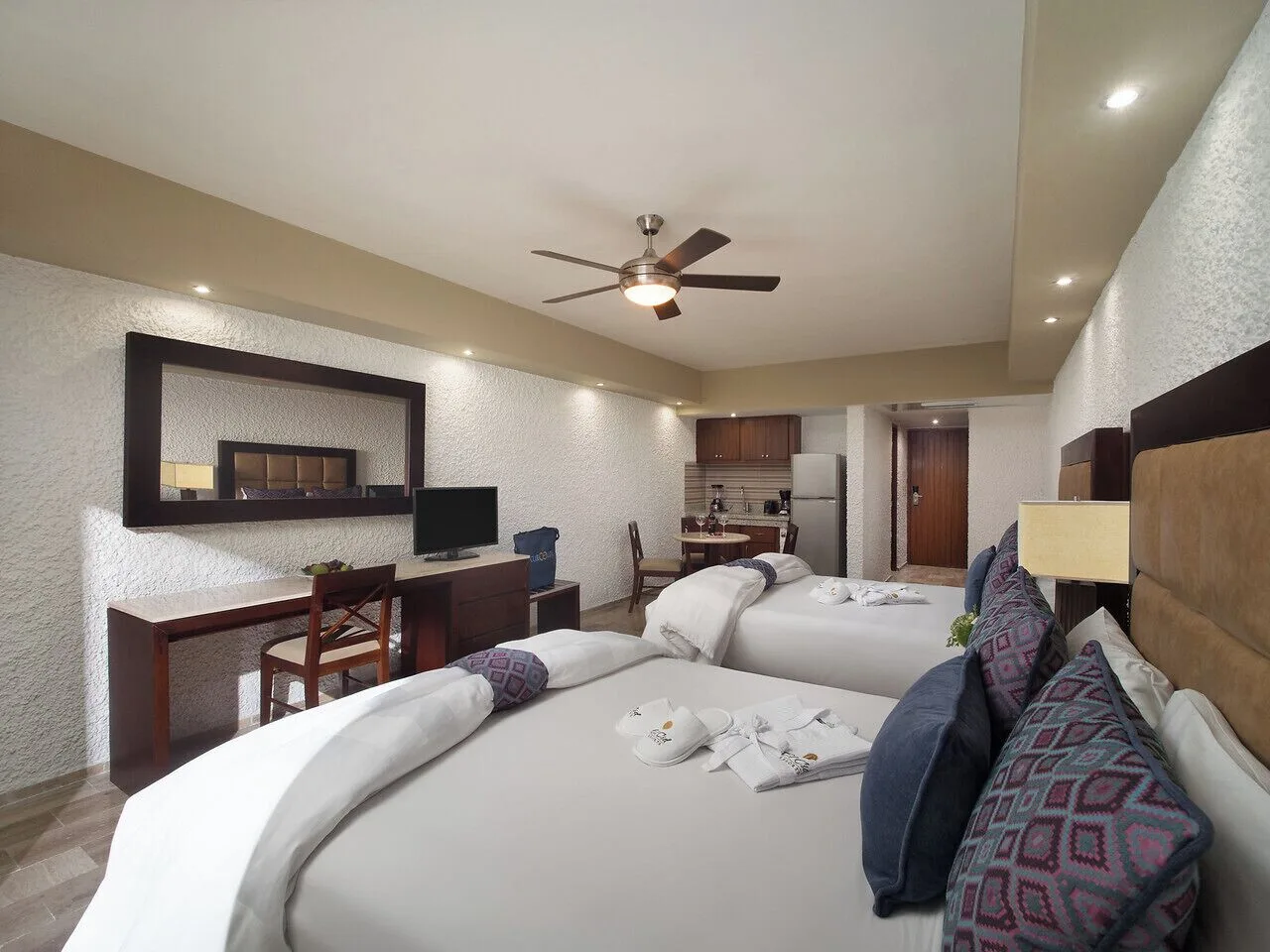 Two-bed guest room with kitchenette and desk at El Cid El Moro Beach Hotel.