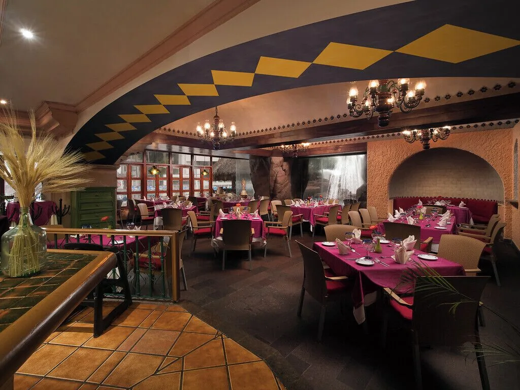 Colorful restaurant dining room with magenta table settings at El Cid El Moro Beach Hotel.