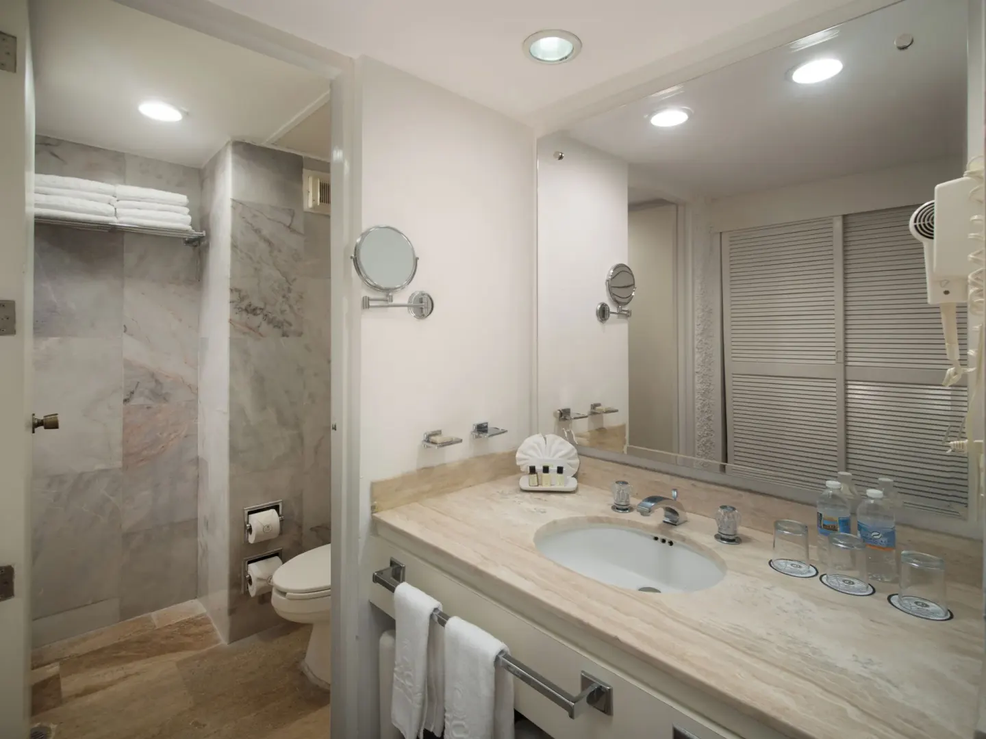 Guest bathroom vanity with shower and towels at El Cid El Moro Beach Hotel.