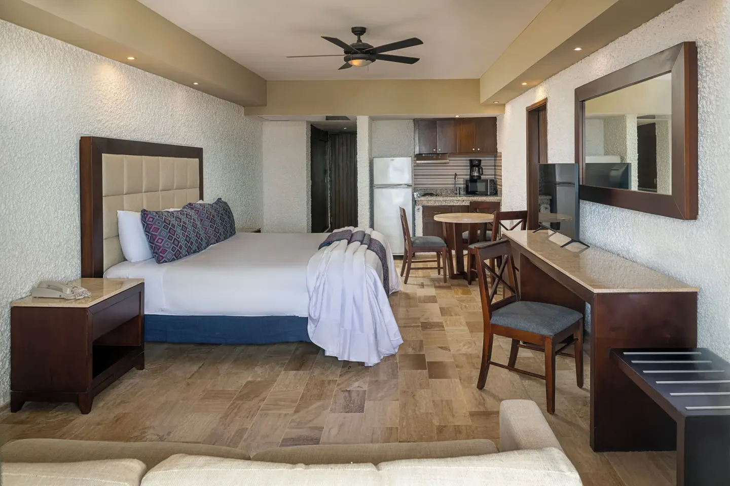 King bed room with kitchenette, desk, and sofa at El Cid El Moro Beach Hotel.