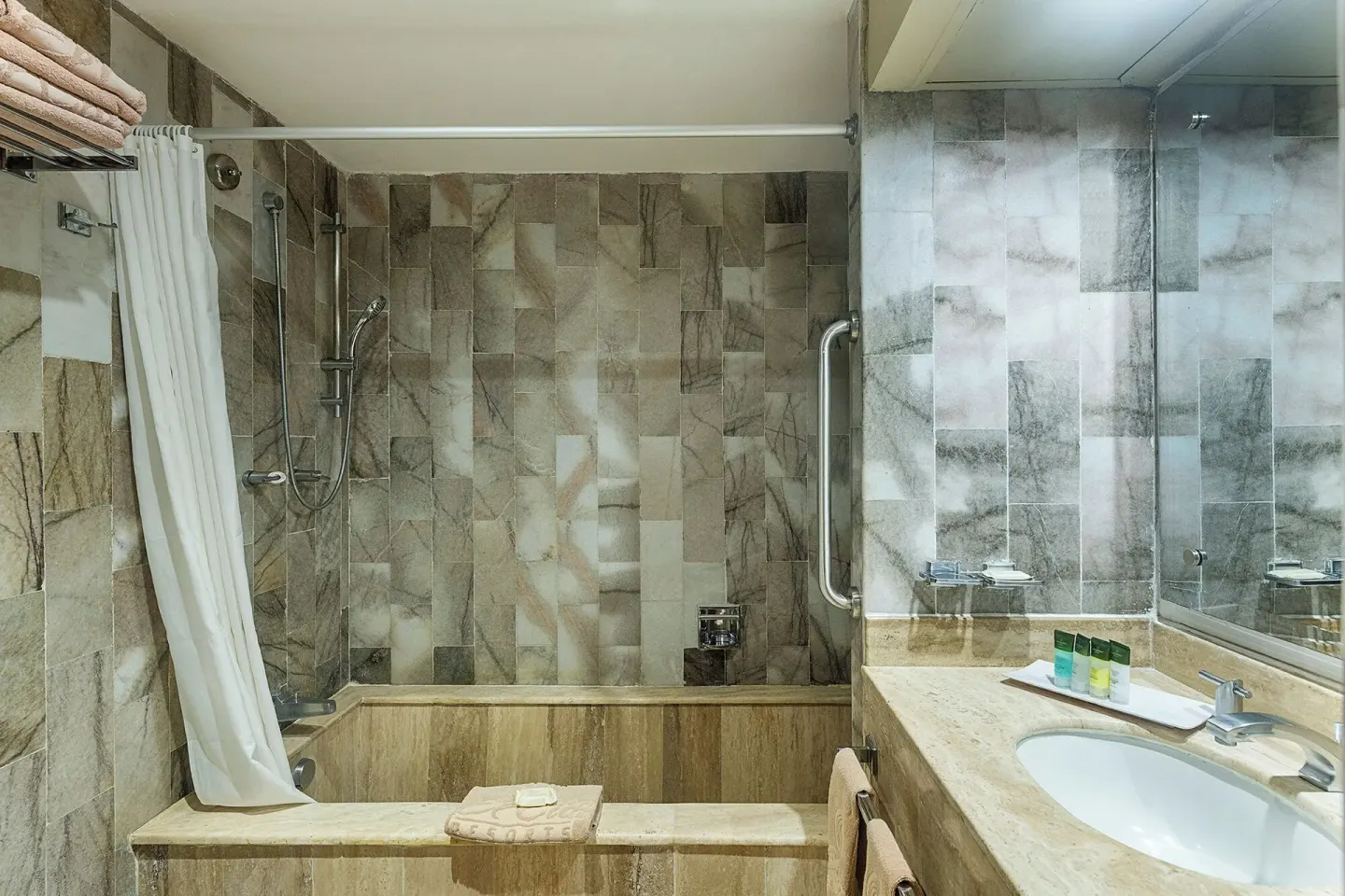 One Bedroom Suite bathroom with tub, shower curtain, vanity, and towels at El Cid El Moro Beach Hotel.
