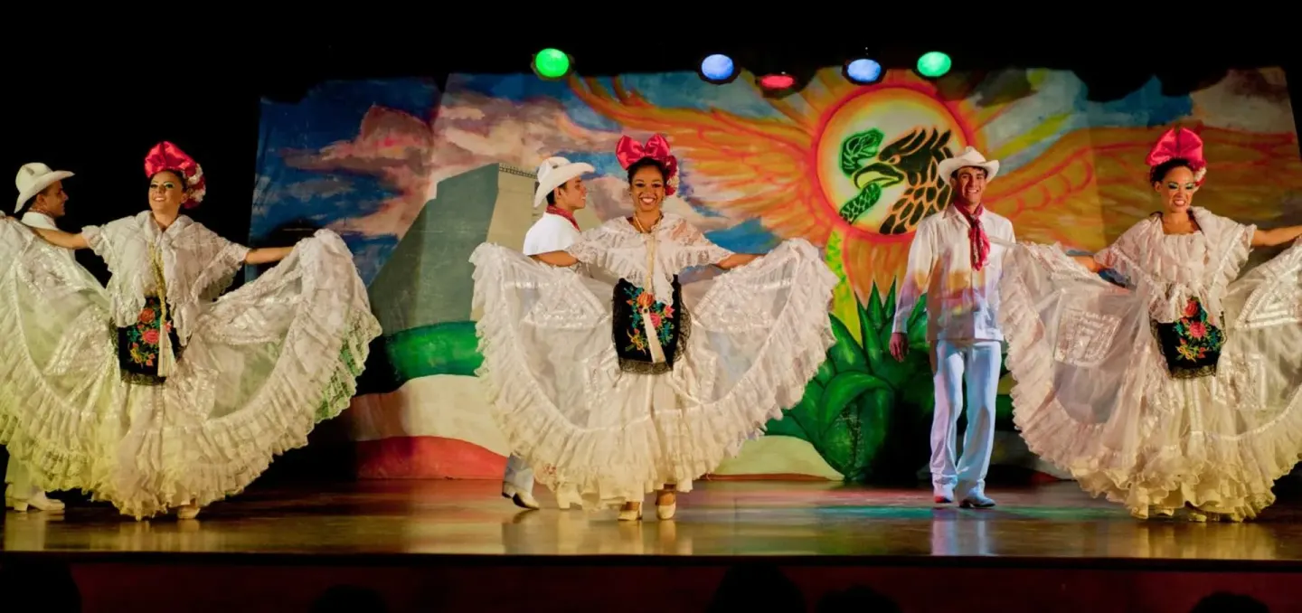 Folkloric dance performance on a colorful stage at El Cid Granada Hotel.