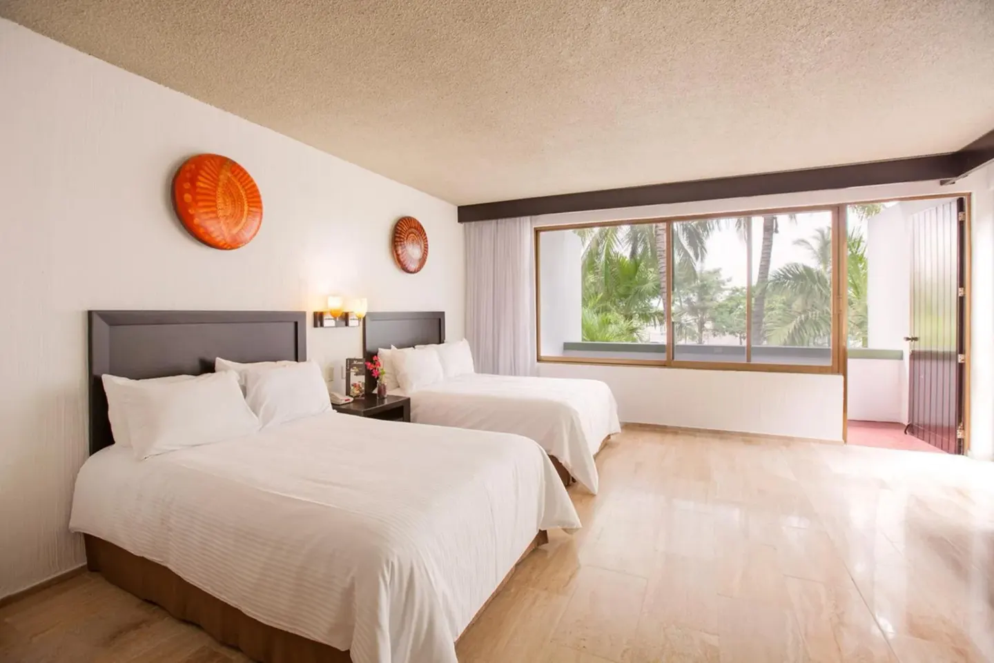 Guest room with two double beds, large window and balcony door at El Cid Granada Hotel.