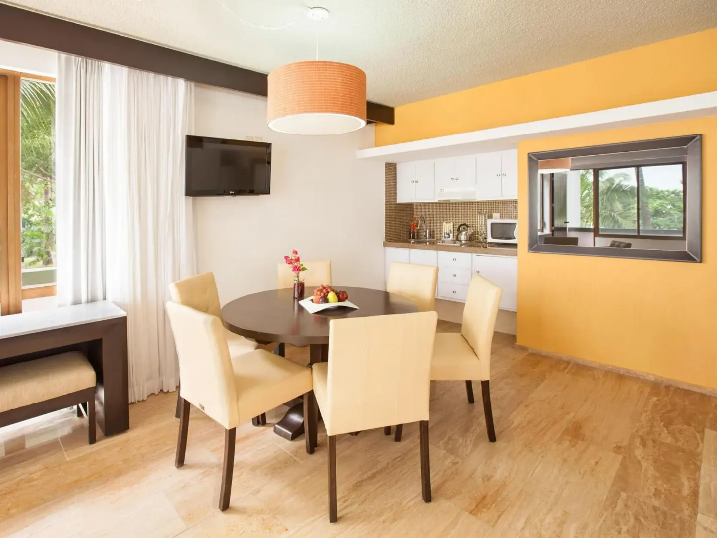 Suite dining area with kitchenette and window at El Cid Granada Hotel.