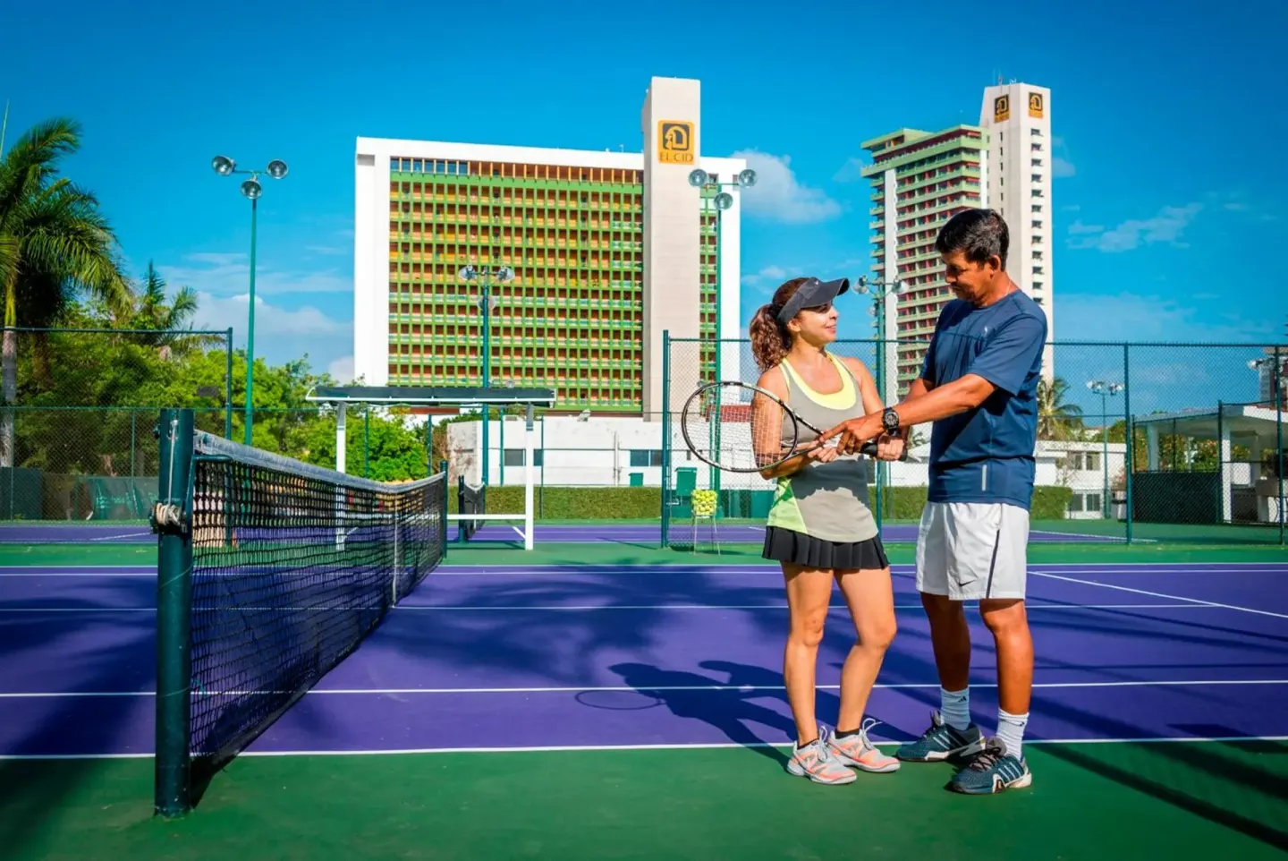 Tennis lesson on a purple and green court at El Cid Granada Hotel.