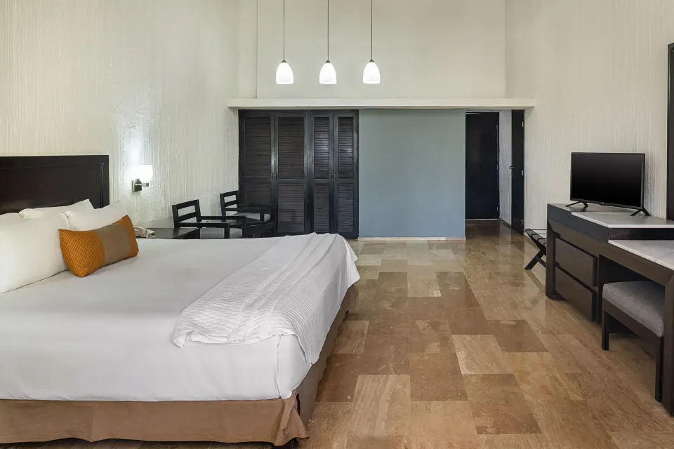 Studio with king bed, desk, TV and closet doors at El Cid Granada Hotel.