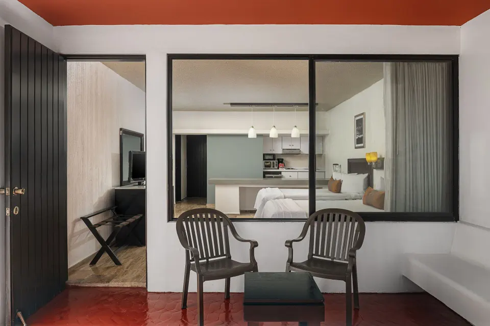 Studio patio with chairs and a view into the room at El Cid Granada Hotel.