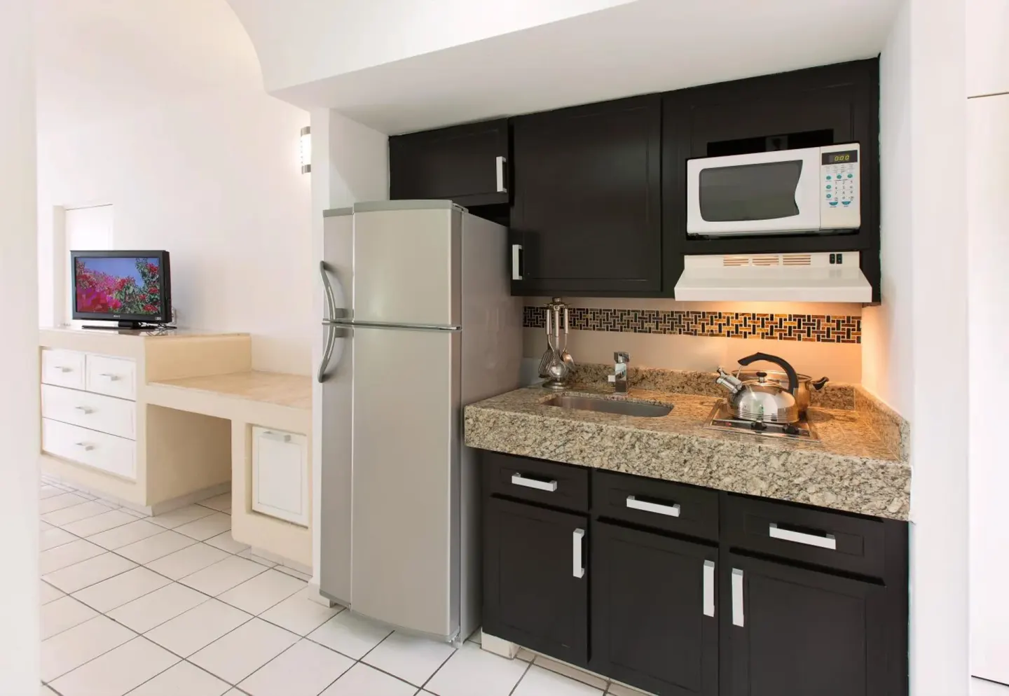 Guest room kitchenette with refrigerator and microwave at El Cid Marina Beach Hotel.