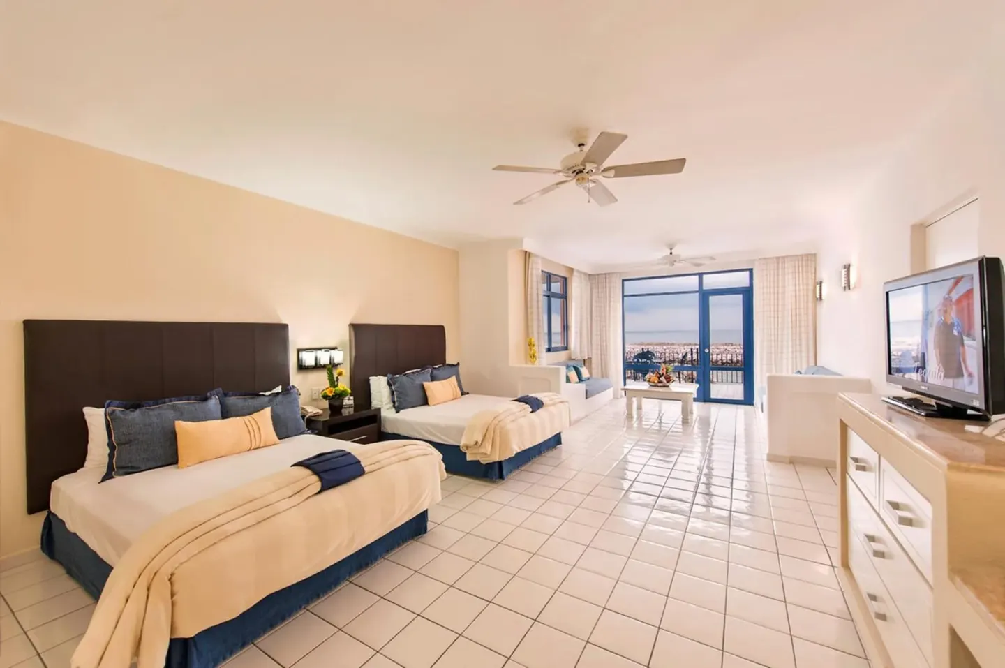 Guest room with two beds and balcony view at El Cid Marina Beach Hotel.