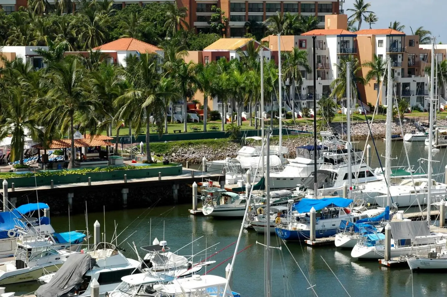 Marina with docked boats and resort buildings at El Cid Marina Beach Hotel.