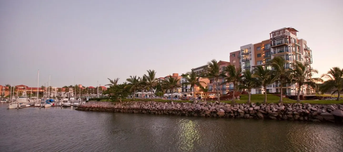 Marina waterfront and hotel buildings at dusk at El Cid Marina Beach Hotel.