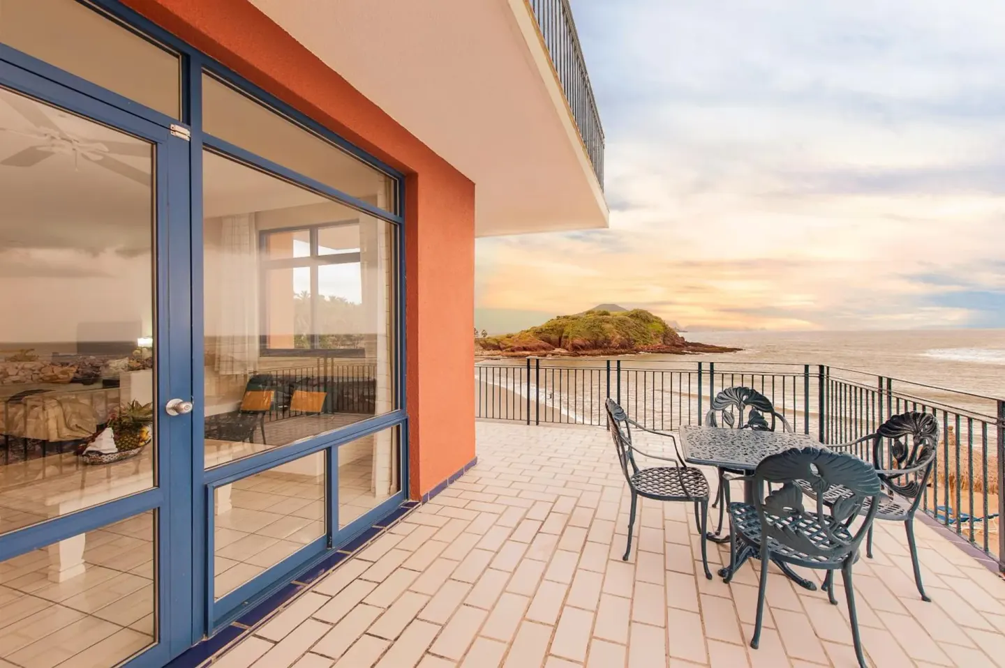Oceanfront terrace with table and chairs at El Cid Marina Beach Hotel.