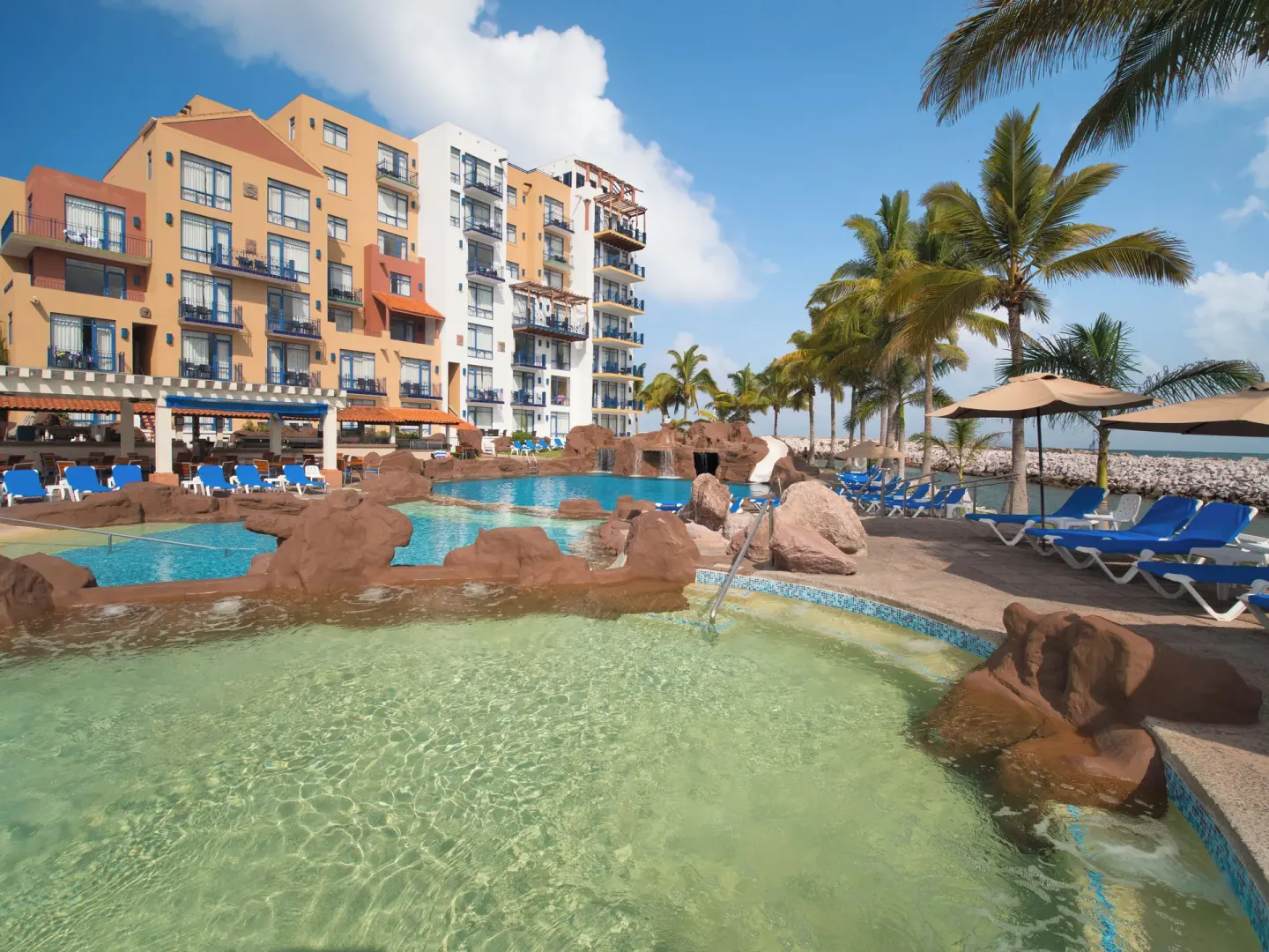 Pool and hot tub area with rock features at El Cid Marina Beach Hotel.